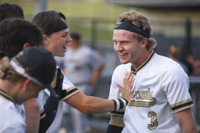 Cullman's Jonah Inman (right) celebrating with teammates after his game-ending grand slam. (Photo via. Lucas Gray)